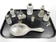 A silver hand mirror and a group of dressing table bottles, some silver-mounted.