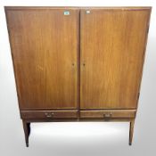 A 20th century Danish teak and ply double door cabinet fitted with shelves and drawers,