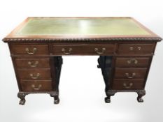 A late Victorian mahogany twin pedestal writing desk, fitted nine drawers,