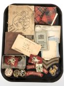 A group of military cap badges and other decorations, related ephemera.