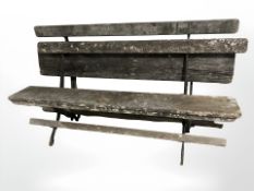 Two antique cast iron framed railway benches with heavily weather seats and back rests,