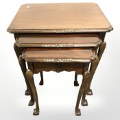 A reproduction mahogany nest of three tables on claw and bell feet,