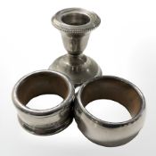 Two silver mounted wooden napkin rings and a loaded silver squat candlestick, height 5.5 cm.