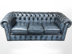 A blue buttoned and studded leather Chesterfield three-seater club settee,