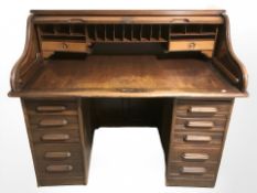 An Edwardian oak twin-pedestal tambour front desk,