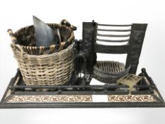 A tiled cast iron fire curb, fire grate, basket, brass footman, companion set,