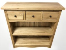 A contemporary oak three drawer side table, 90 cm x 29 cm x 95 cm.