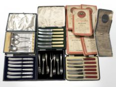 A group of boxed cutlery and several ordnance survey folding maps.