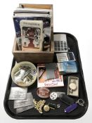A group of lapel pins, calculators, rugby match tickets, map measure, assorted badges,