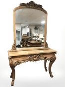 A heavily carved pine console table and mirror above, overall 138 cm x 42 cm x 224 cm.