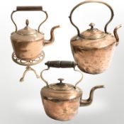 A brass trivet and three Victorian copper kettles, largest 31 cm high.