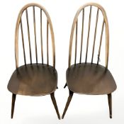 A pair of Ercol stained elm spindle back dining chairs.