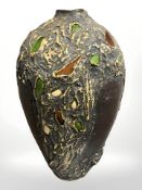 An earthenware pottery vase with inset coloured glass fragments, height 50 cm.