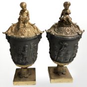 A pair of patinated and gilt bronze lidded urns, cast in high relief with putti, height 41.5 cm.