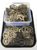 A collection of horse brasses, some on leather straps, decorative miniature sword.