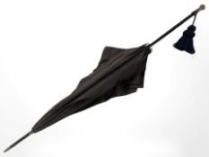 An antique parasol with silver pommel