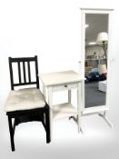 A contemporary white side table, cheval mirror and a chair.
