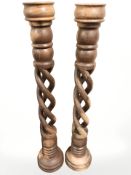 A pair of carved hardwood barley twist candle stands, height 92 cm.