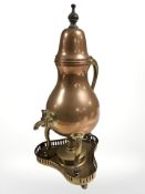 A copper tea urn and a brass burner stand.