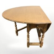 A reproduction oak drop leaf table,