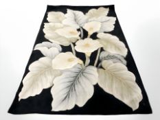 A machine made floral carpet on black ground, 255 cm x 160 cm.