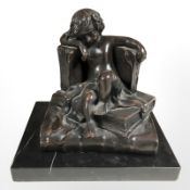 An Art Deco style bronzed statue of a boy sat on a stack of books, on black marble plinth,