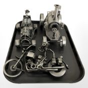 Three contemporary metal models of a steam engine, a car and a motorbike.