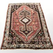 A Khamseh rug, South-West Iran, the stepped raspberry lozenge field centred by an anchor medallion,