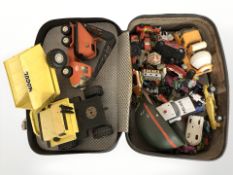 A suitcase containing die cast vehicles, excavators, cranes, etc, including Tonka, Corgi, etc.