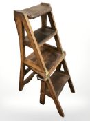 An Edwardian oak metamorphic library chair.
