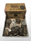 A vintage money box and British Victorian and later pre-decimal coins, and a silver fob.