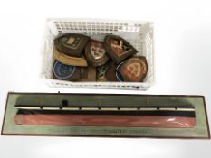 A painted wooden relief picture of a ship and a group of plaques on oak shields.