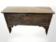 A George III oak coffer with later carved decoration,