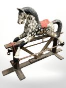A 20th century painted composition rocking horse on stained pine stand,