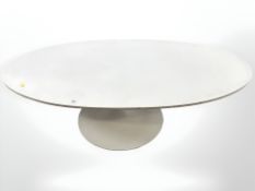 An oval coffee table on metal conical support,