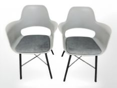 A pair of moulded plastic chairs.