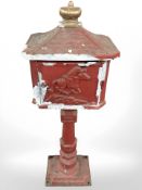 A reproduction painted metal letterbox, height 105 cm.