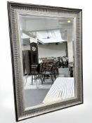A bevelled contemporary mirror with silvered frame, 91 cm x 65 cm.