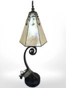 A metal table lamp with decorative glass shade,