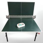 A Kettler folding table tennis table with net, three bats and balls, width 153cm.