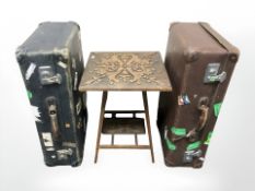 An Edwardian carved oak occasional table and two 20th century luggage cases