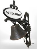 A cast welcome sign bell on bracket.