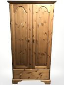 A pine double door wardrobe, fitted a drawer, width 100 cm, height 191.5 cm.