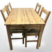 A contemporary pine dining room table, width 120 cm and four pine rush-seated ladder back chairs.