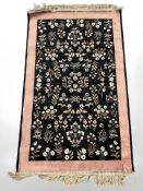 A silk piled rug with floral design,
