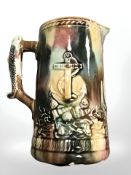 A nineteenth century English majolica glazed jug with nautical decorations and fish handle,