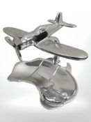 An aluminium polished aeroplane on map base.