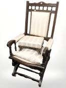 An Edwardian rocking chair upholstered in cream fabric with matching footstool.