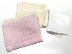 Three mid-20th century quilts in white, pink and yellow.