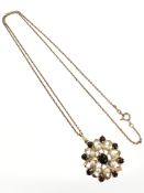A yellow gold garnet and seed pearl pendant, diameter 20 mm, suspended on 9ct yellow gold chain,
